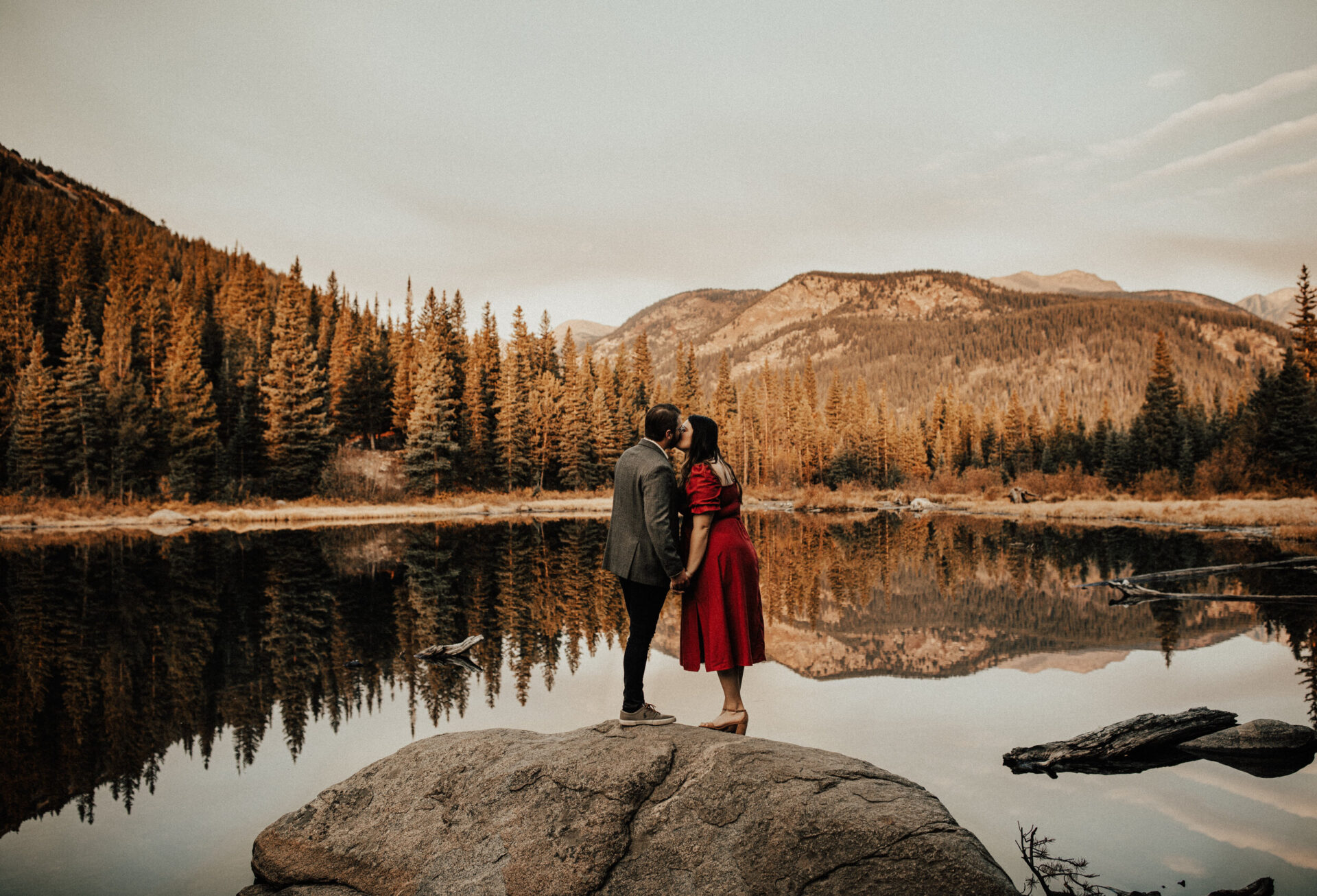 couple kissing on rock along the shore of lost lake near Boulder, CO